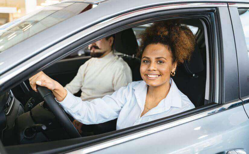 Donna che ha appena che guida auto acquistata tramite noleggio a lungo termine